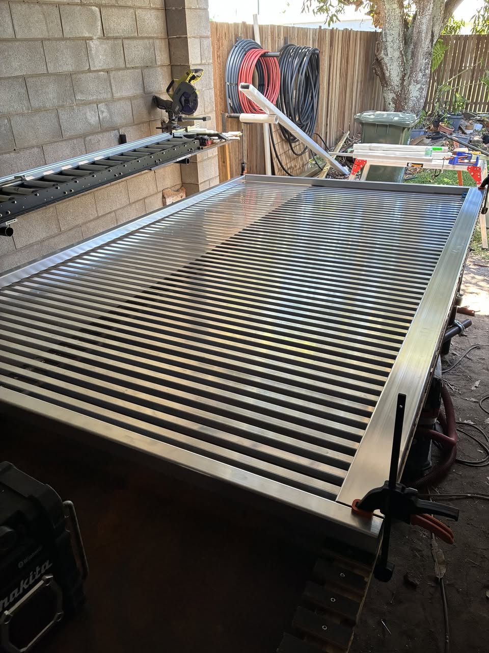 In-house gate fabrication - custom aluminium slatted gate frame being built in workshop