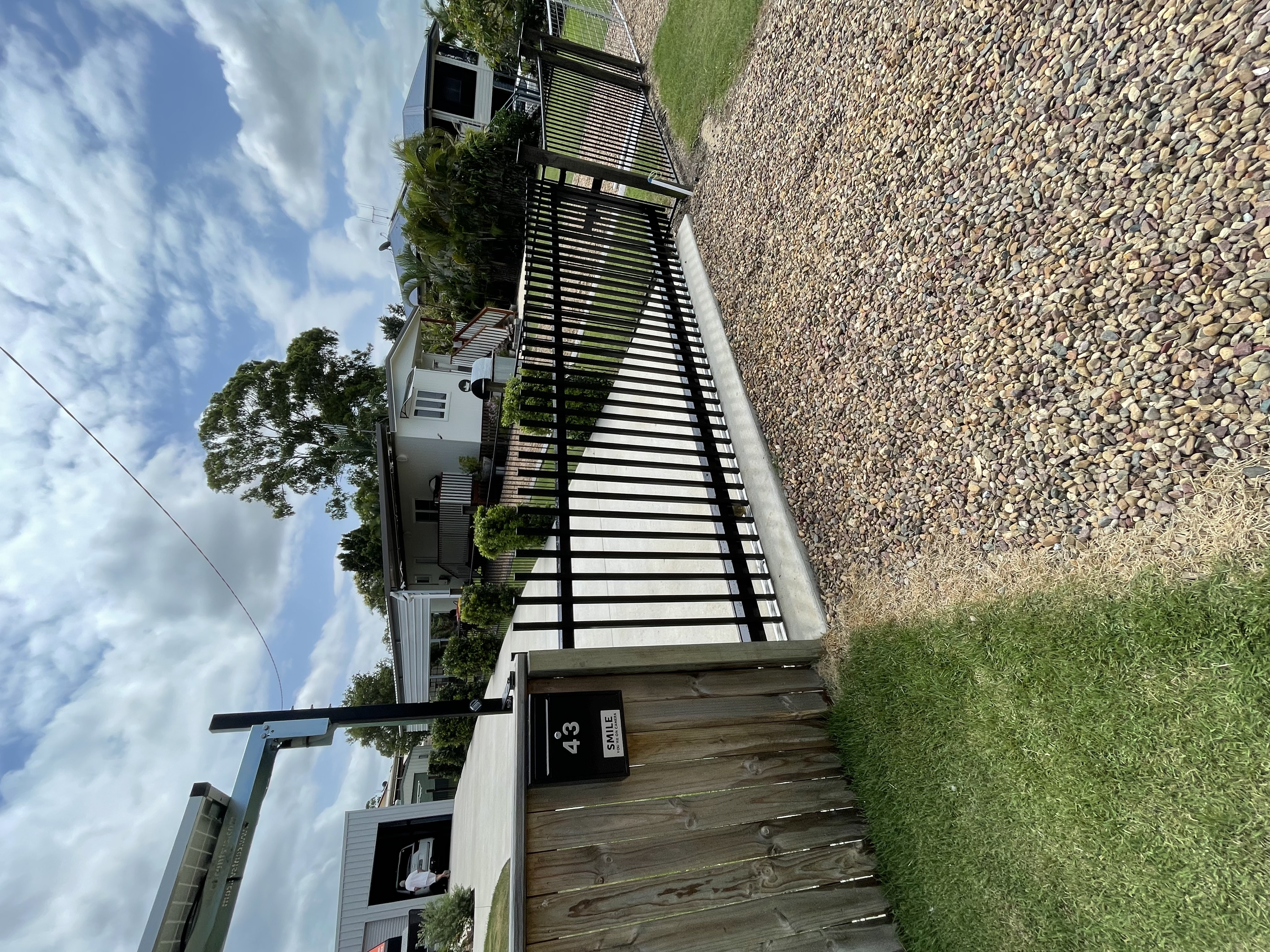 Black metal automatic gate with mailbox - recent Bundaberg installation by Coastal Automation